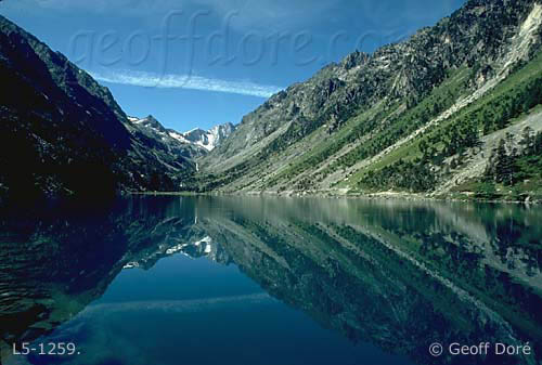 Mountain slopes and reflections in Gaube Lake, summer, High Pyrenees, France