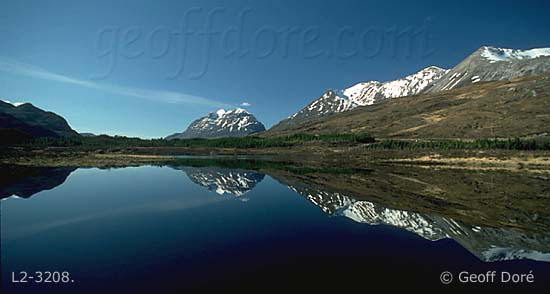 Ben Liath and Ben Eigh mountains with reflection in loch, Scotland